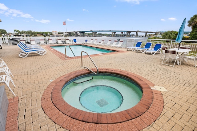 community pool featuring a hot tub and a patio