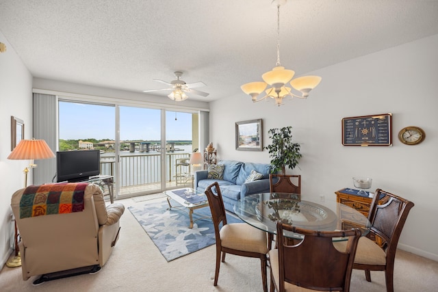 living area featuring carpet flooring, a chandelier, healthy amount of natural light, and a textured ceiling