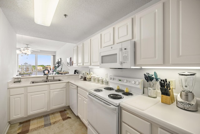 kitchen featuring white appliances, a sink, white cabinetry, light countertops, and a textured ceiling