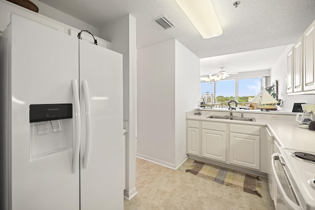 kitchen featuring white appliances, a sink, light countertops, white cabinetry, and a textured ceiling