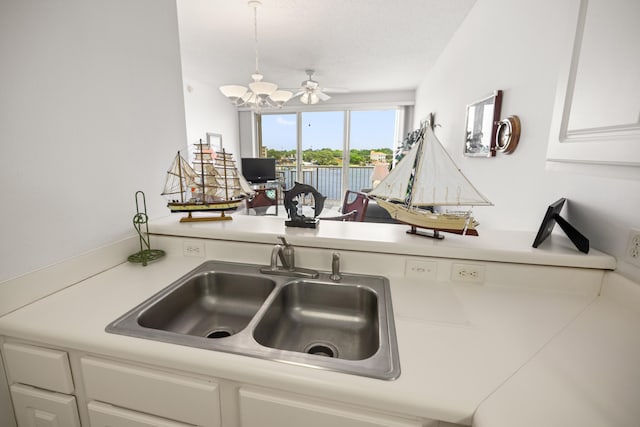 kitchen featuring a sink, light countertops, white cabinets, and ceiling fan