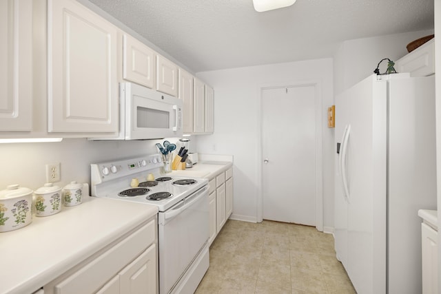 kitchen with white appliances, light countertops, and white cabinetry