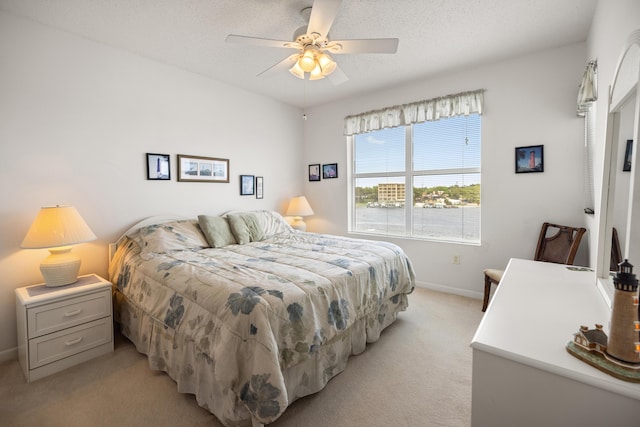 bedroom featuring light carpet, baseboards, and ceiling fan