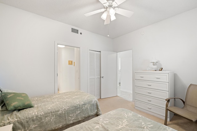 bedroom with light colored carpet, a closet, vaulted ceiling, and ceiling fan