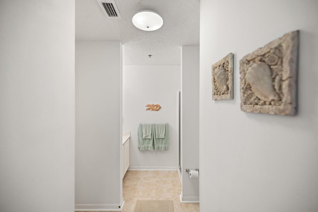 bathroom featuring a textured ceiling and baseboards