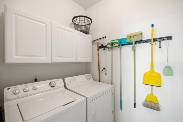 washroom with separate washer and dryer and cabinet space