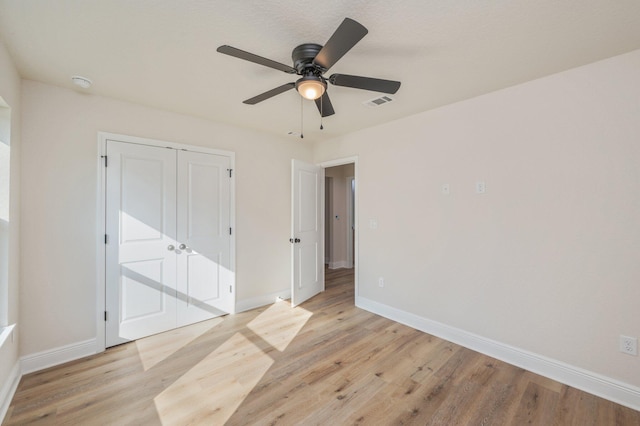 empty room featuring baseboards, light wood-style floors, ceiling fan, and a smoke detector