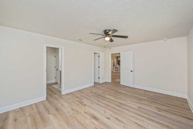 unfurnished bedroom with light wood-style floors, baseboards, a ceiling fan, and a textured ceiling