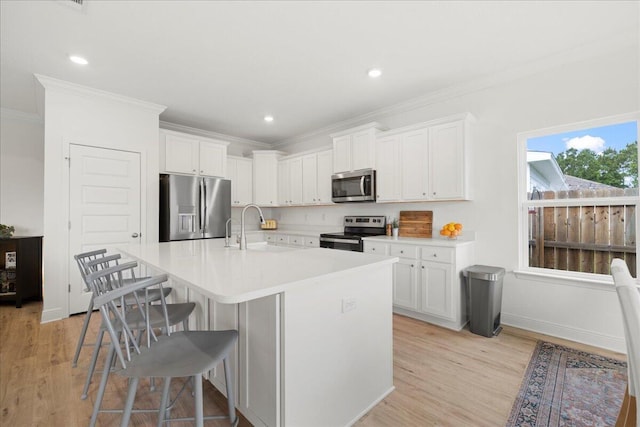 613 Las Roblas Grande Dr, Santa Rosa Beach, FL 32459 - kitchen with appliances with stainless steel finishes, a sink, crown molding, a kitchen breakfast bar, and light wood-style flooring