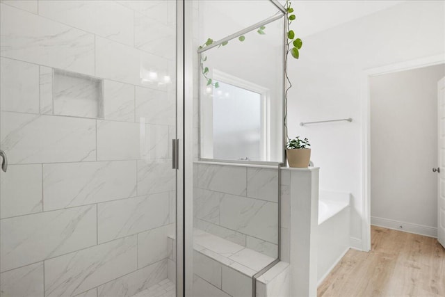 613 Las Roblas Grande Dr, Santa Rosa Beach, FL 32459 - bathroom featuring a stall shower, a garden tub, wood finished floors, and baseboards