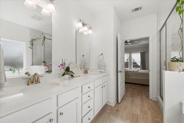 613 Las Roblas Grande Dr, Santa Rosa Beach, FL 32459 - ensuite bathroom with wood finished floors, a stall shower, double vanity, and a ceiling fan