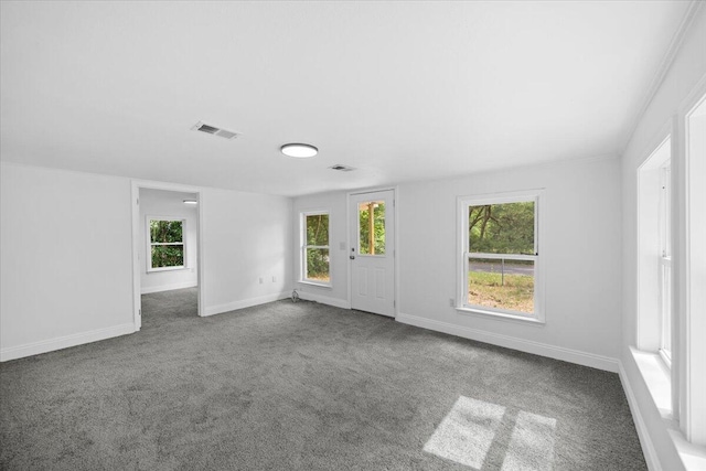unfurnished room with carpet flooring, plenty of natural light, and baseboards