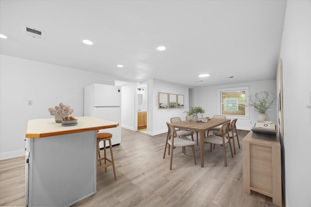dining space with light wood finished floors, recessed lighting, and baseboards