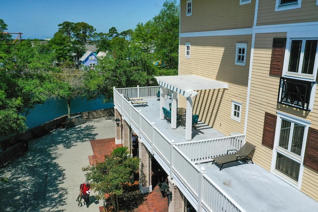 wooden terrace featuring a patio and a water view