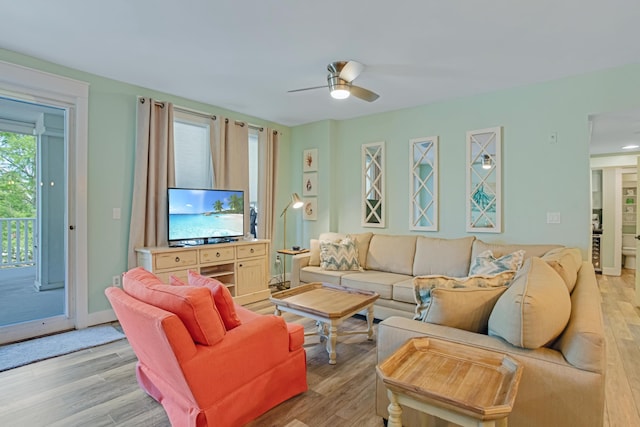living room with a ceiling fan and light wood-type flooring
