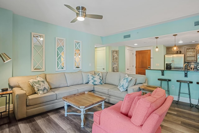 living room with dark wood-type flooring, a ceiling fan, and recessed lighting