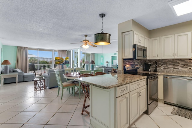 30 Moreno Point Rd Unit 206B, Destin, FL 32541 - kitchen featuring stainless steel appliances, open floor plan, tasteful backsplash, a textured ceiling, and light tile patterned flooring