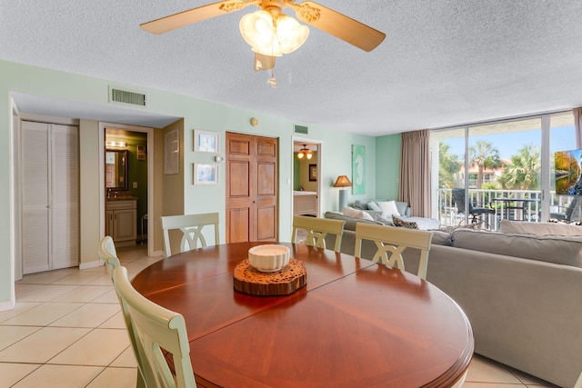 30 Moreno Point Rd Unit 206B, Destin, FL 32541 - dining space with light tile patterned flooring, ceiling fan, a textured ceiling, a wall of windows, and baseboards