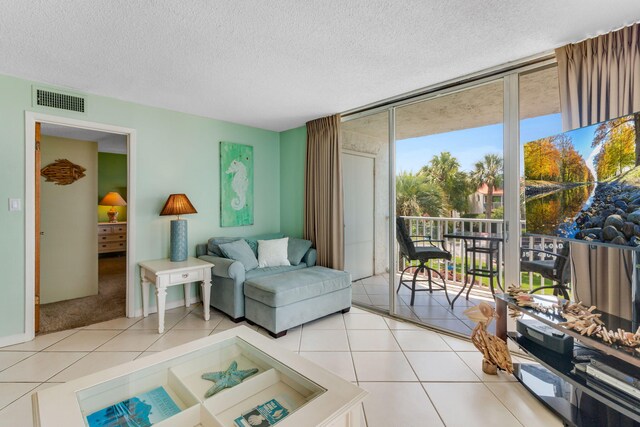 30 Moreno Point Rd Unit 206B, Destin, FL 32541 - living area with a textured ceiling, floor to ceiling windows, and light tile patterned floors