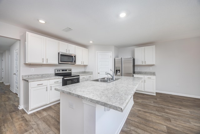 kitchen featuring appliances with stainless steel finishes, a sink, baseboards, white cabinetry, and dark wood-style floors