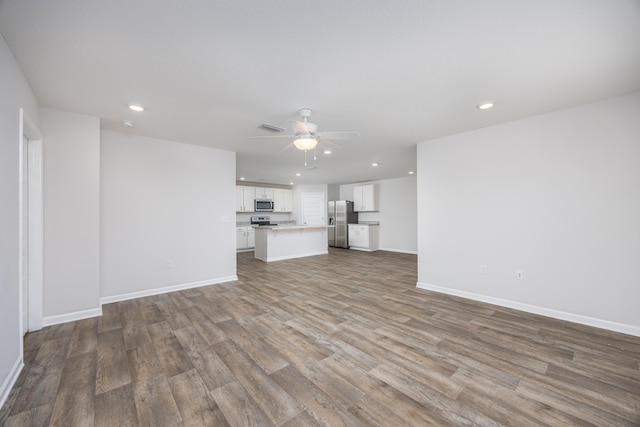 unfurnished living room with recessed lighting, wood finished floors, baseboards, and a ceiling fan