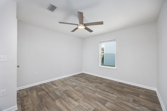 spare room with ceiling fan, wood finished floors, and baseboards