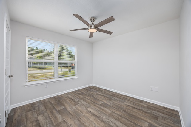 empty room with dark wood finished floors, ceiling fan, and baseboards