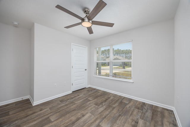 unfurnished room featuring a ceiling fan, dark wood-style floors, and baseboards