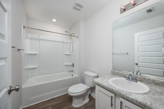 bathroom featuring wood finished floors, toilet, vanity, shower / tub combination, and baseboards