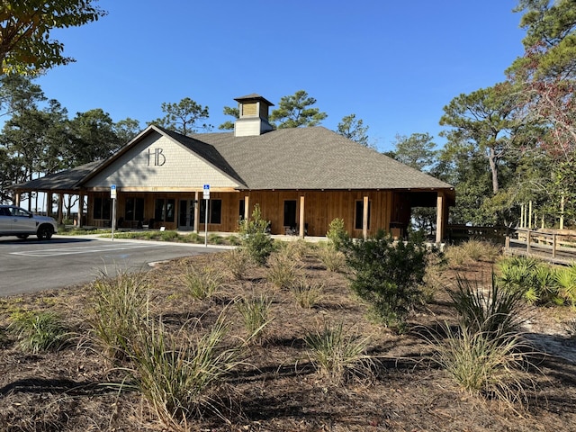 view of front of home featuring a chimney, board and batten siding, and roof with shingles