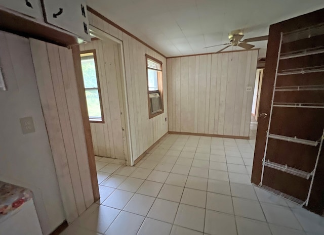 unfurnished room with a ceiling fan, wood walls, and baseboards