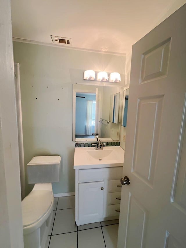 half bathroom featuring tile patterned floors, vanity, toilet, and baseboards
