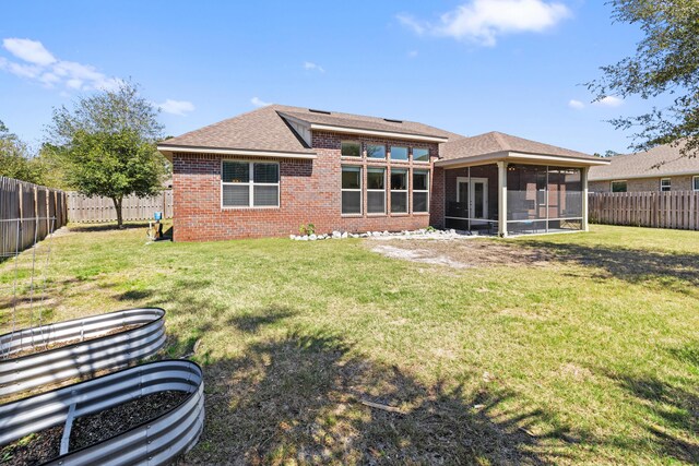 495 Brighton Cv, Freeport, FL 32439 - rear view of property featuring a sunroom, brick siding, and roof with shingles