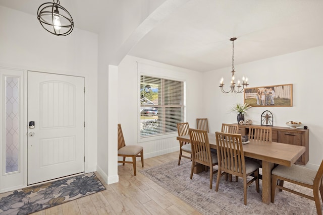 495 Brighton Cv, Freeport, FL 32439 - dining area with a chandelier, light wood-type flooring, baseboards, and arched walkways