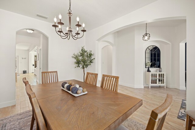 495 Brighton Cv, Freeport, FL 32439 - dining room featuring a chandelier, light wood-style flooring, and baseboards