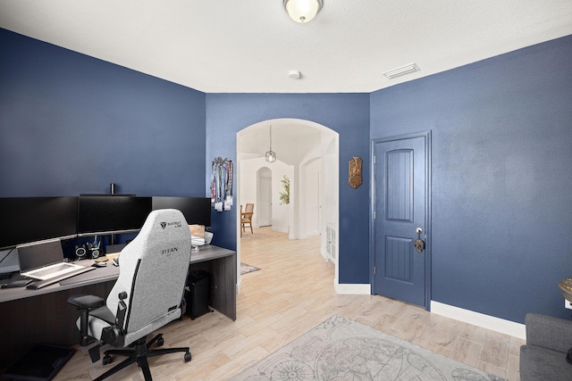 495 Brighton Cv, Freeport, FL 32439 - home office featuring arched walkways, wood finished floors, and baseboards