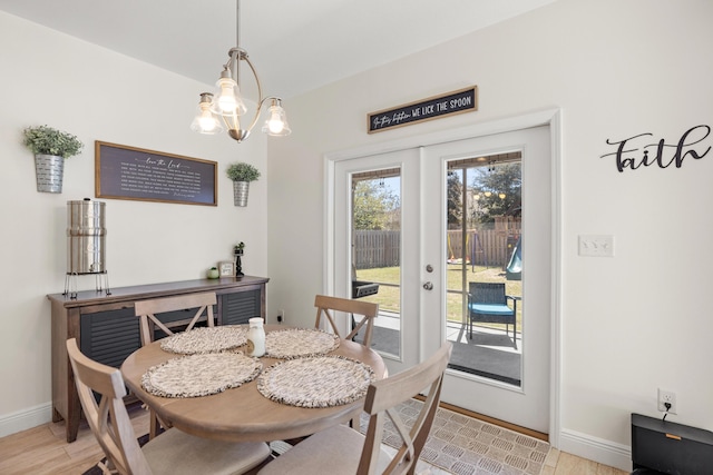 495 Brighton Cv, Freeport, FL 32439 - dining room with baseboards, light wood finished floors, and a chandelier