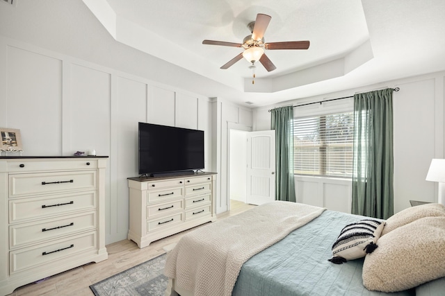 495 Brighton Cv, Freeport, FL 32439 - bedroom featuring a tray ceiling, light wood-type flooring, and ceiling fan