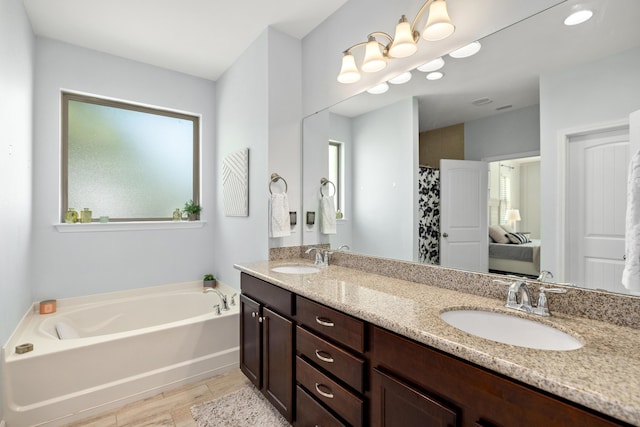 495 Brighton Cv, Freeport, FL 32439 - bathroom with plenty of natural light, a bath, double vanity, and wood finished floors