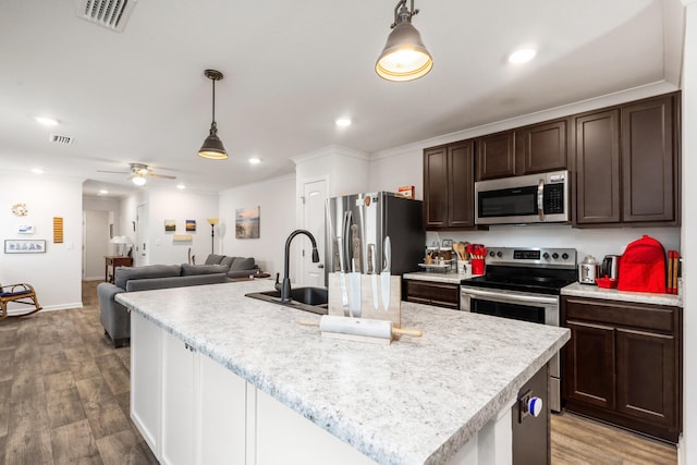 595 Earl Godwin Rd, Freeport, FL 32439 - kitchen with appliances with stainless steel finishes, dark brown cabinetry, light countertops, pendant lighting, and wood finished floors