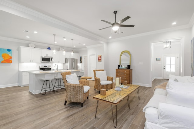 27 Cozy Cv, Freeport, FL 32439 - living room with light wood finished floors, baseboards, a ceiling fan, recessed lighting, and ornamental molding