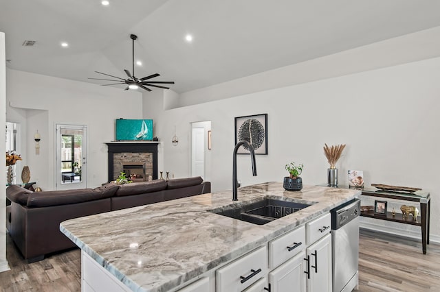 137 Loblolly Bay Dr, Santa Rosa Beach, FL 32459 - kitchen featuring a sink, dishwasher, open floor plan, light stone counters, and light wood-style floors
