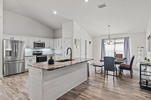 137 Loblolly Bay Dr, Santa Rosa Beach, FL 32459 - kitchen featuring stainless steel appliances, a sink, lofted ceiling, white cabinetry, and light stone counters