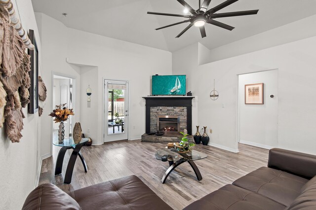 137 Loblolly Bay Dr, Santa Rosa Beach, FL 32459 - living area with a ceiling fan, light wood-type flooring, a stone fireplace, a high ceiling, and baseboards