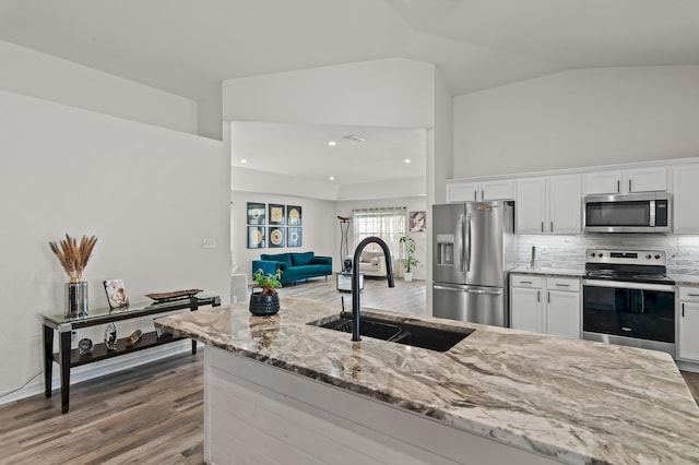 137 Loblolly Bay Dr, Santa Rosa Beach, FL 32459 - kitchen featuring appliances with stainless steel finishes, a sink, light stone countertops, white cabinets, and lofted ceiling