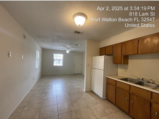 818 Lark St Unit 1, 2, 3, 4, Fort Walton Beach, FL 32547 - kitchen featuring freestanding refrigerator, brown cabinetry, ceiling fan, light countertops, and a textured ceiling