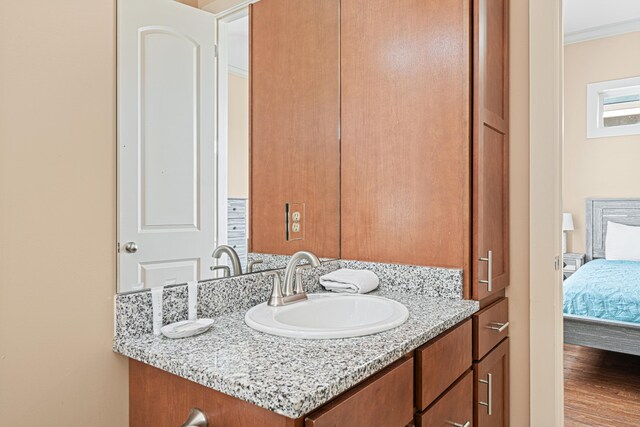 6236 Thomas Dr, Panama City Beach, FL 32408 - bathroom with wood finished floors, vanity, ensuite bathroom, and ornamental molding