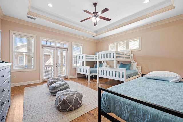 6236 Thomas Dr, Panama City Beach, FL 32408 - bedroom featuring a tray ceiling, multiple windows, crown molding, wood finished floors, and recessed lighting