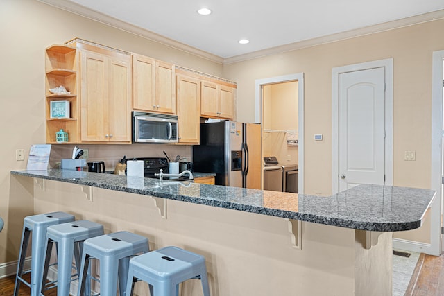6236 Thomas Dr, Panama City Beach, FL 32408 - kitchen with washer and clothes dryer, appliances with stainless steel finishes, light brown cabinetry, crown molding, and light wood-style floors