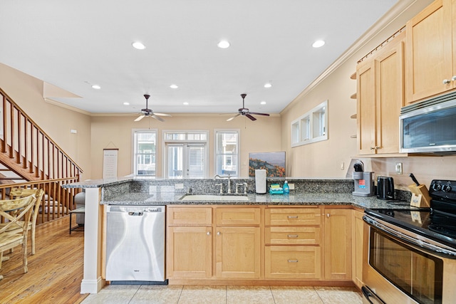 6236 Thomas Dr, Panama City Beach, FL 32408 - kitchen with appliances with stainless steel finishes, a peninsula, light brown cabinets, a sink, and ornamental molding